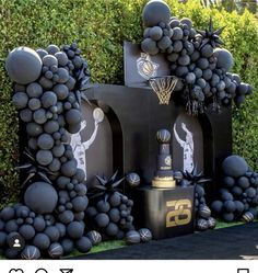 a bunch of balloons that are in the shape of numbers and basketballs on display