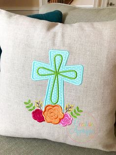 a pillow with a cross and flowers on it