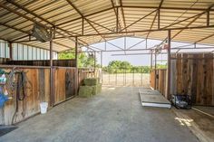 the inside of a horse barn with hay and other things on the ground in it