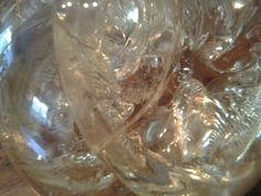 a glass bowl filled with ice cubes on top of a wooden table