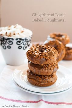 three chocolate donuts stacked on top of each other next to a cup of coffee