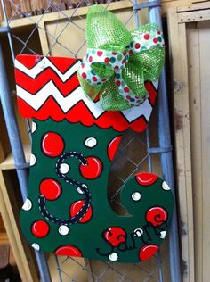 a green and red christmas stocking hanging on a fence