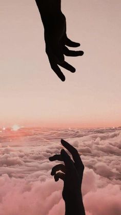 two hands reaching for each other above the clouds