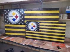 two wooden boards with the pittsburgh football logo painted on them, sitting in a workshop