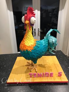 there is a cake made to look like a rooster on top of a board with the number 5