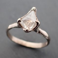 a white diamond ring sitting on top of a table