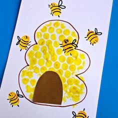 a handprinted card with bees and a tree made out of yellow paper on a blue background