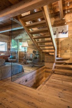 a bedroom with wooden walls and stairs leading up to the loft