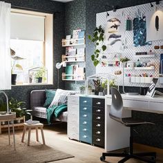 a living room filled with furniture and lots of plants on the wall next to a window