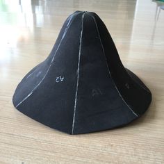 a black cone shaped object sitting on top of a wooden floor