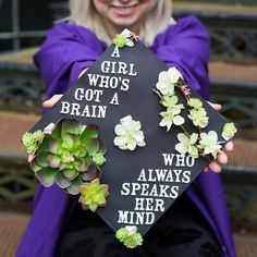 a woman is holding a graduation cap with succulents on it that says a girl who's got a brain