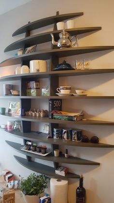 the shelves are filled with dishes and cups