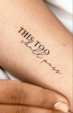 a woman's leg with the words, this too pray on it in cursive font