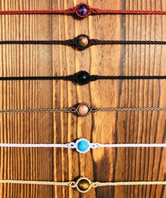 five different colored bracelets on top of a wooden table