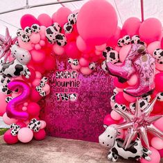 pink and black balloons are on display in front of a wall with cowgirl decorations