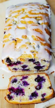 a loaf of lemon blueberry bread on a cutting board with a slice cut out