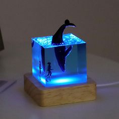 a blue light that is on top of a wooden block with a shark in it