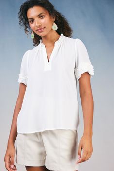 The silhouette of this short-sleeve blouse may be simple, but pleated trim and layered ruffle detailing set it apart. Featuring a split neckline with gentle gathers, the popover style elevates your look with minimal effort. •Split neckline •Short sleeves •Pleated trim with ruffle detailing •Relaxed fit Item number 2330159 100% Polyester Gentle Cycle Cold Chic Short Sleeve Top For Spring Workwear, Feminine Short Sleeve Tops With Ruffles, Chic Short Sleeve Blouse With Ruffle Hem, Short Sleeve Blouse With Ruffle Hem, Elegant Flutter Sleeve Tops For Daywear, Elegant Blouse With Ruffle Hem, Chic Short Sleeve Top For Work, Feminine Solid Color Blouse With Ruffle Sleeves, White Short Sleeve Tops With Ruffle Hem