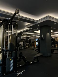 an empty gym with equipment in the middle and lights on above it's ceiling