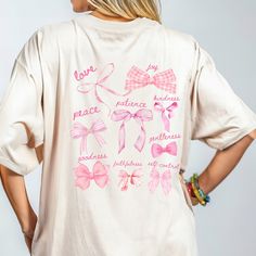 Walk in the Fruit of the Spirit  with our coquette bow oversized Jesus shirt, featuring a vibrant graphic tee designed adorned with inspiring Bible verse Galatians 5:22-23. Crafted for comfort in mind and made from premium materials, this Christian shirt of the Fruit of the Spirit is the perfect blend of faith and fashion. Order today! 🌺 PRODUCT DESCRIPTION -Front print says 'Galatians 5:22-23' -Back print says love, joy, peace, patience, kindness, goodness, faithfulness, gentleness & self cont Spring Casual Shirt With Bow, Cotton T-shirt With Bow Print For Spring, Spring Cotton T-shirt With Bow Print, Cotton Tops With Bow Print And Short Sleeves, Casual Tops With Bow Print For Spring, Casual Bow Print Tops For Spring, Jesus Shirts Women, Christian Coquette, Country Wedding Gifts