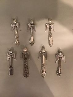 six silver spoons with angel designs on them