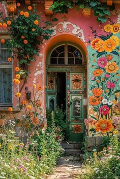 an old house with flowers painted on the front door and side windows, along with plants and flowers