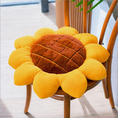 a sunflower shaped cushion sitting on top of a wooden chair