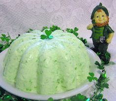 a cake with green frosting sitting on top of a table next to shamrock leaves