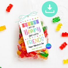 a bag filled with gummy bears on top of a white table next to colorful candies