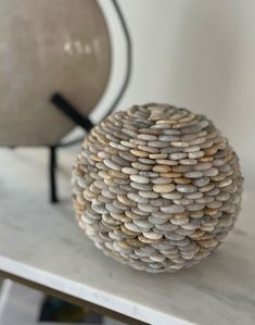 a stone ball sitting on top of a table next to a light brown sphere lamp