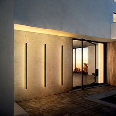 an entrance to a modern house with glass doors