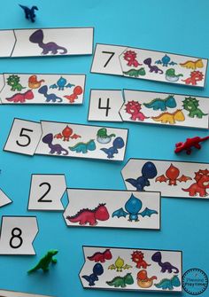 the dinosaur numbers are displayed on a blue background with scissors and paper cutouts to match them