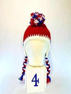 a red white and blue knitted hat with the number four on it