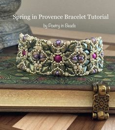 a bracelet is sitting on top of a book with beads and stones in it's center