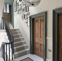 an entry way with stairs and pictures on the wall