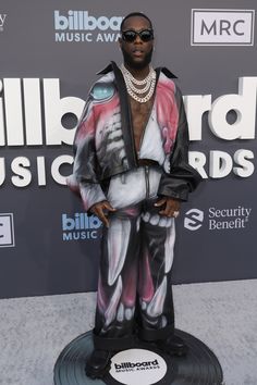 a man in black and white outfit standing on top of a record