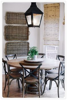 a dining room table and chairs in front of a window with blinds on the wall