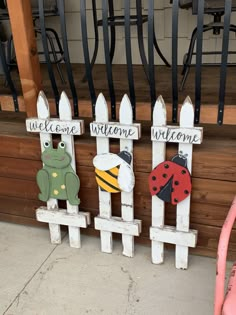 three wooden welcome signs sitting next to each other