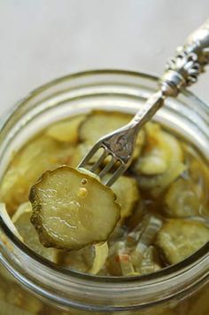 a fork in a jar filled with bread and butter pickles