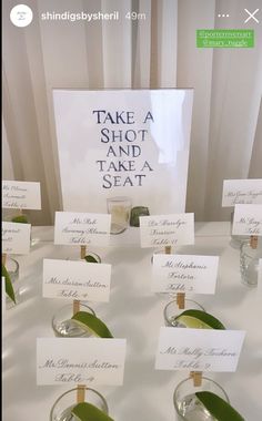 there are many small glasses on the table with place cards for each guest to take