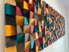 a wall hanging made out of wood with different colored squares on it's sides