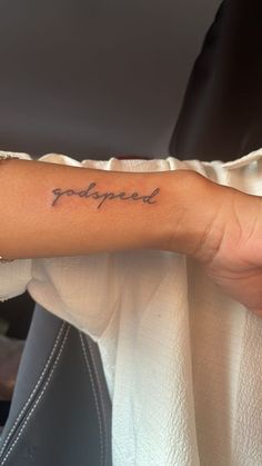 a woman's arm with the word poopied tattooed on it