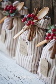 wooden spoons are wrapped in burlocks and tied with twine, holly berries and cinnamon sticks