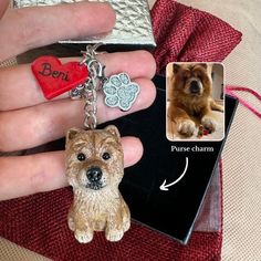 a person's hand holding a dog keychain