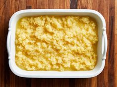 a casserole dish filled with mashed potatoes on top of a wooden table