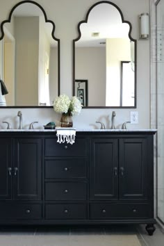 a bathroom with double sinks and mirrors on the wall