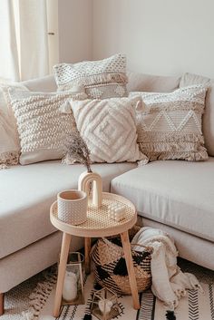 a white couch with pillows and a table