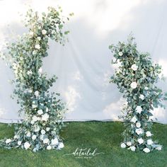 two tall white flowers and greenery on the grass