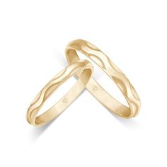 two gold wedding bands with wavy design on each band, one in the shape of a heart