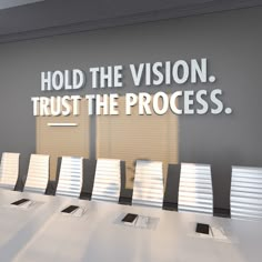 a conference room with a large sign that says hold the vision, trust the process